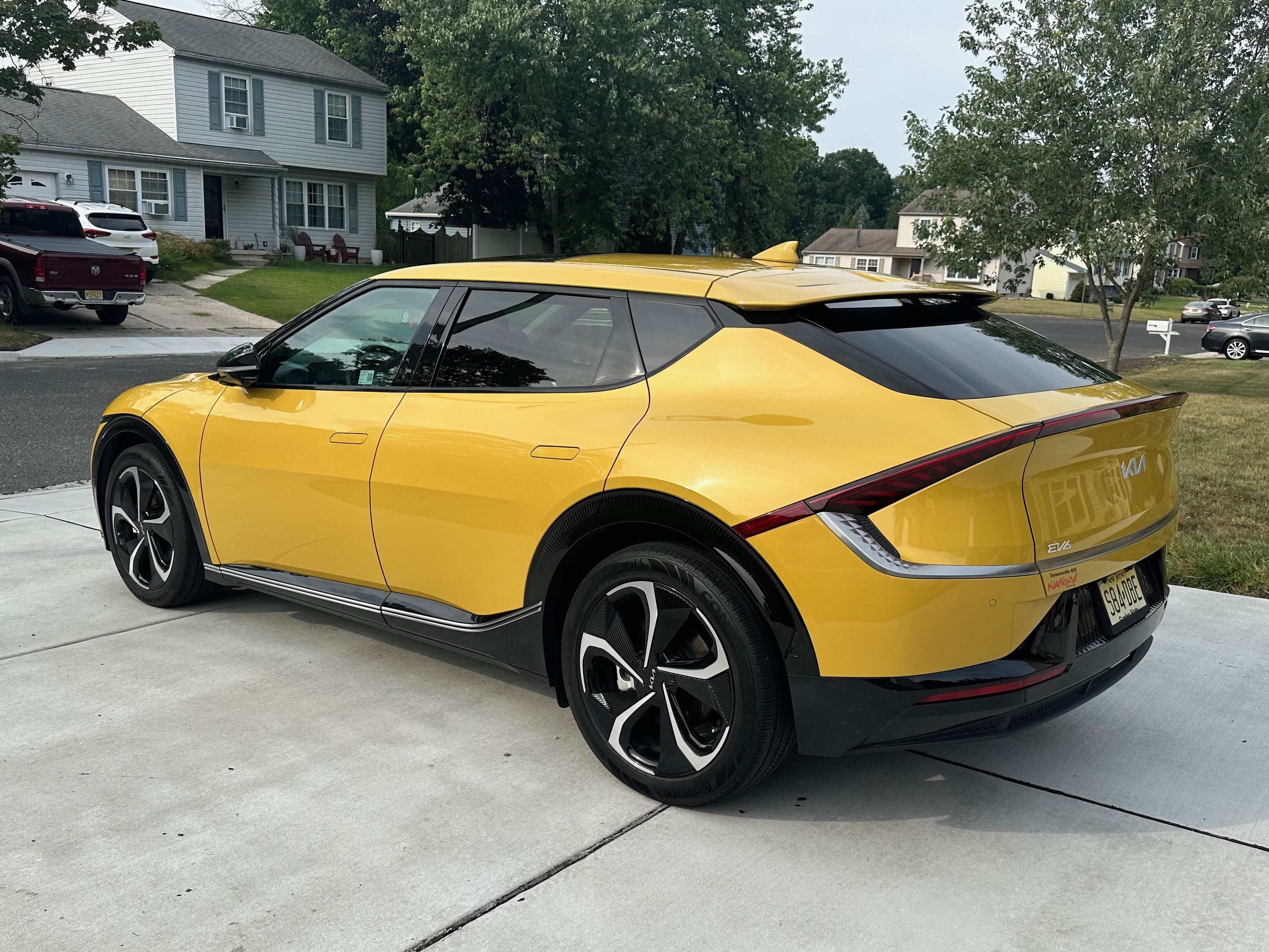 A yellow Kia EV6 parked in a driveway.